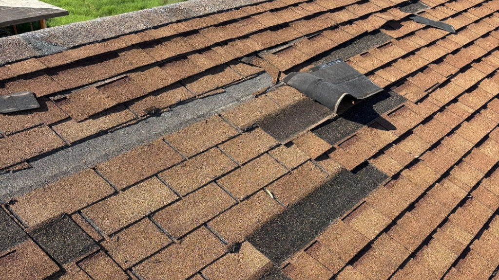 Storm damaged clay tile roof with broken tiles